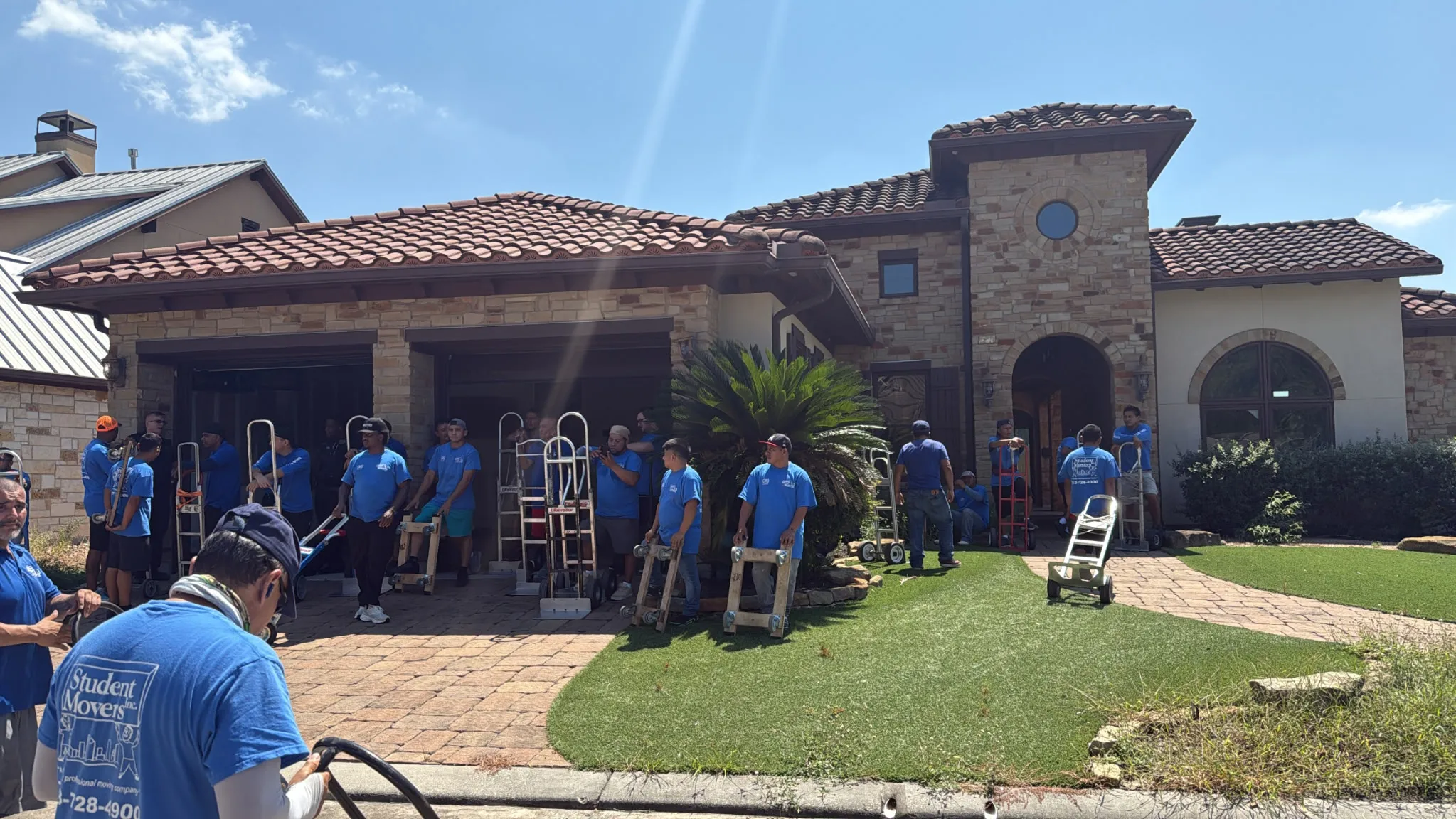Student Movers team providing residential moving services at a large suburban home.