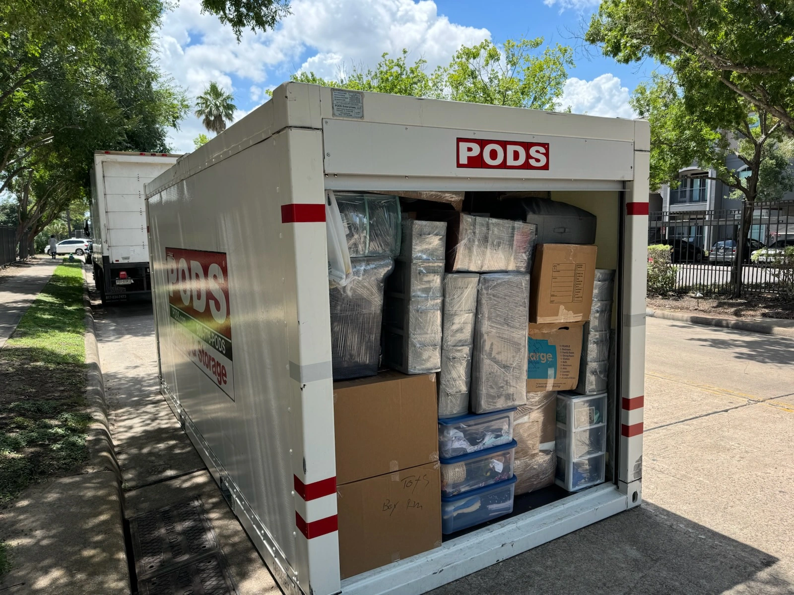 Transparent moving container filled with organized boxes and packing supplies.